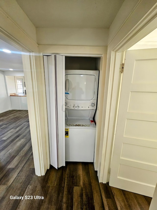 washroom with stacked washer and clothes dryer and dark hardwood / wood-style floors