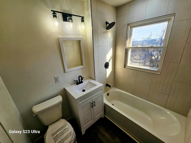 full bathroom featuring tiled shower / bath combo, vanity, and toilet