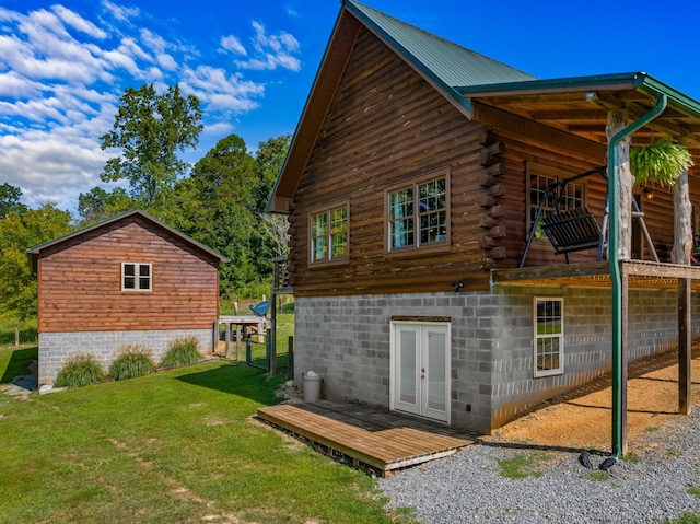 back of property with a lawn and french doors