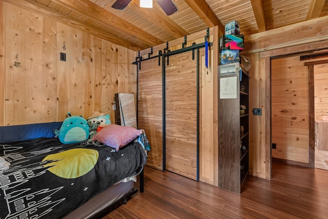 bedroom featuring beamed ceiling, ceiling fan, dark wood-type flooring, and wooden walls