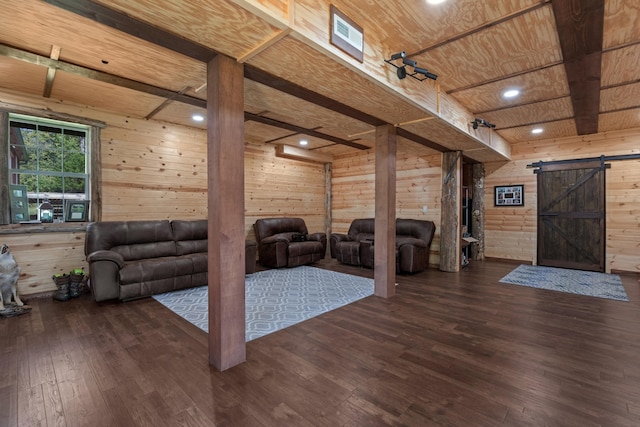 living room with a barn door, wooden walls, wood ceiling, and dark hardwood / wood-style floors