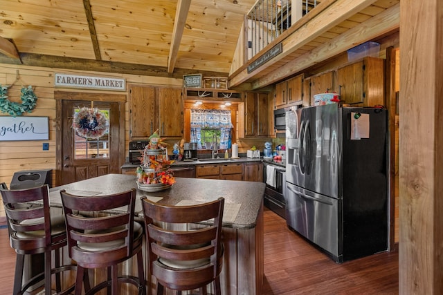 kitchen with wood ceiling, stainless steel appliances, wooden walls, sink, and dark hardwood / wood-style floors