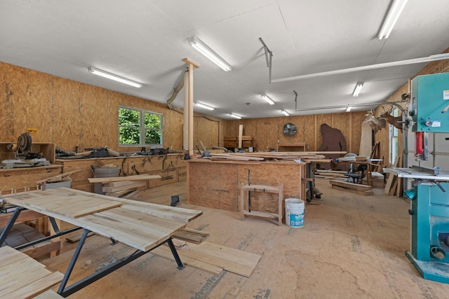 miscellaneous room with a workshop area and wood walls