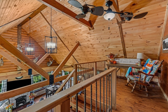 interior space with wood-type flooring, lofted ceiling with beams, rustic walls, and wooden ceiling