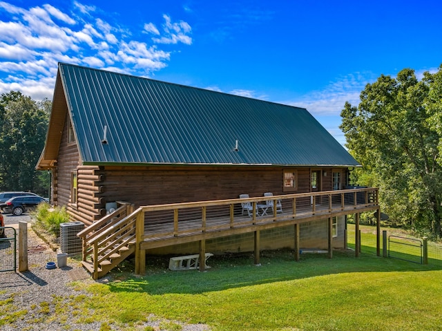 back of house with a lawn, a wooden deck, and central AC