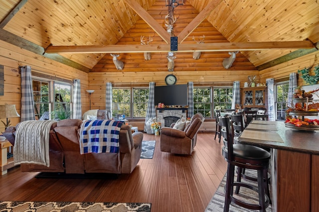 living room with a healthy amount of sunlight, wooden ceiling, and wood walls