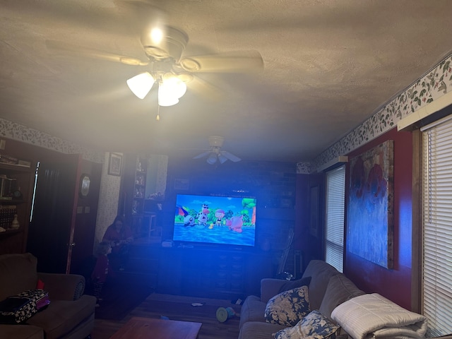 living room featuring ceiling fan and a textured ceiling