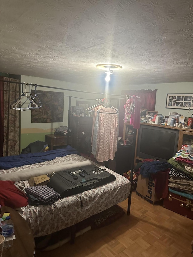 bedroom with parquet floors and a textured ceiling