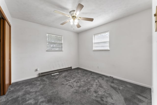 unfurnished room with ceiling fan, dark carpet, and baseboard heating