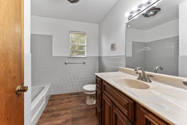 bathroom featuring vanity, toilet, wood-type flooring, and tile walls