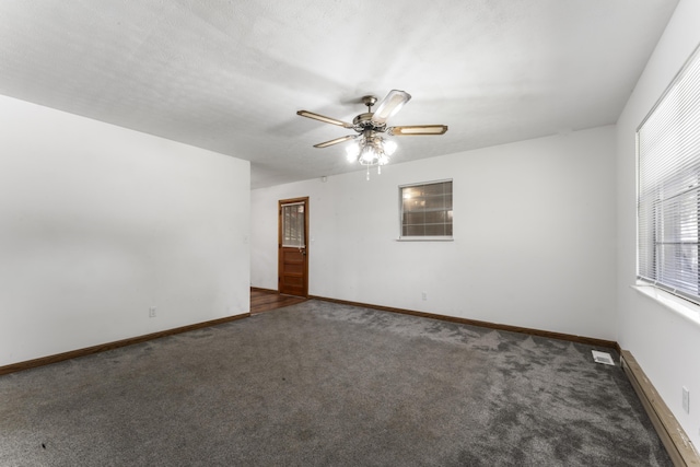 unfurnished room featuring dark colored carpet and ceiling fan