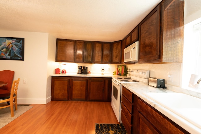 3501 Grassy Fork Rd, Hartford, TN 37753 - kitchen with white appliances, light wood-style flooring, light countertops, baseboards, and a sink