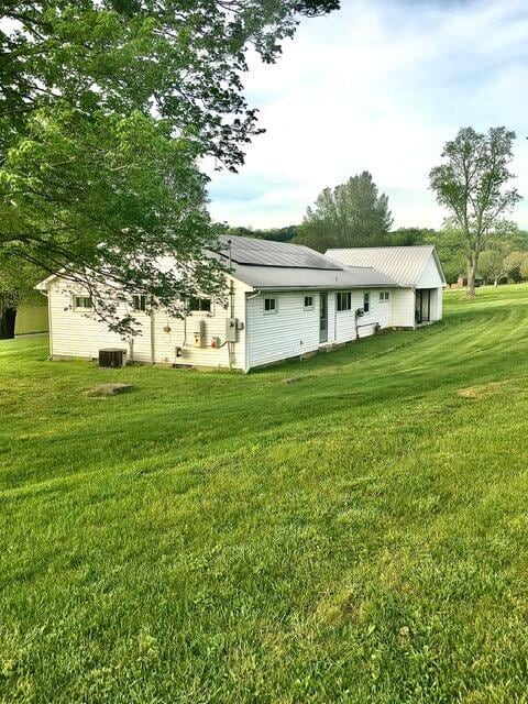 exterior space featuring central AC and a yard