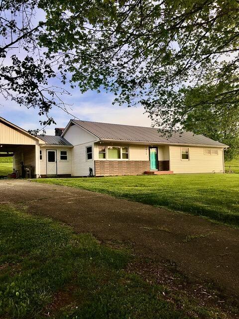 back of house featuring a yard and a carport