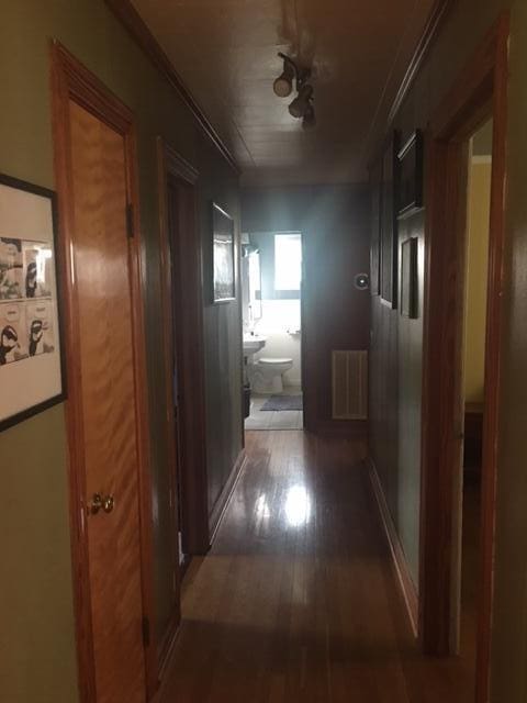 corridor featuring dark hardwood / wood-style flooring and radiator