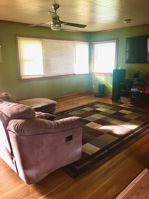 living room featuring wood-type flooring and ceiling fan