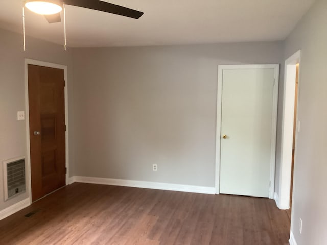 unfurnished room featuring heating unit, dark hardwood / wood-style floors, and ceiling fan