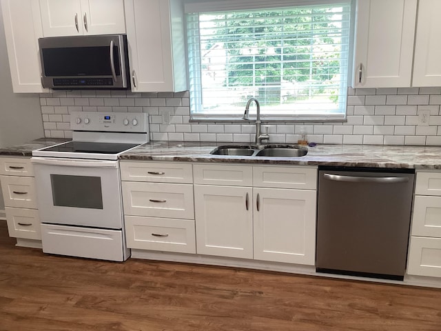 kitchen featuring dark wood-type flooring, sink, light stone counters, white cabinetry, and stainless steel appliances