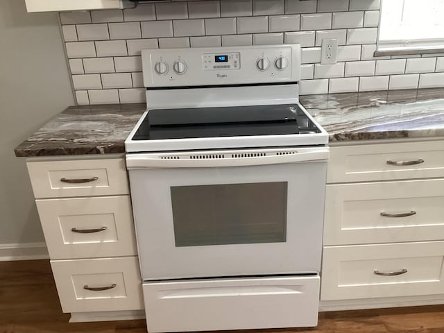 kitchen with decorative backsplash, white cabinets, dark hardwood / wood-style floors, and white electric range