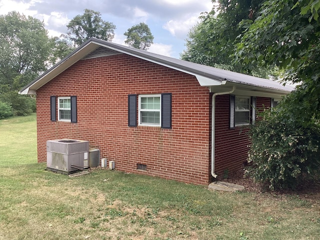 view of side of property with a yard and central AC unit