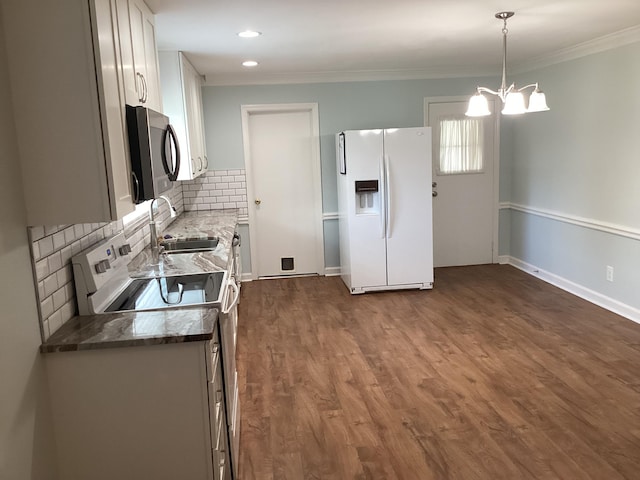 kitchen featuring white fridge with ice dispenser, sink, range with electric stovetop, a chandelier, and pendant lighting