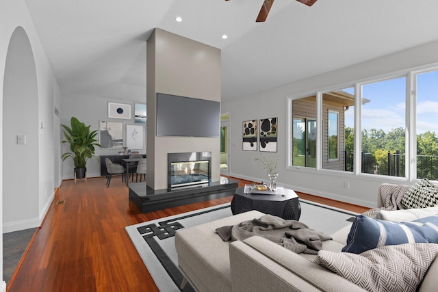 living room with ceiling fan, lofted ceiling, and dark hardwood / wood-style flooring