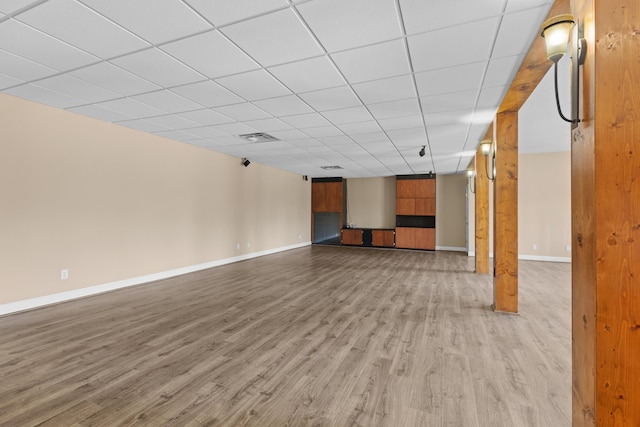 unfurnished living room featuring a paneled ceiling and light hardwood / wood-style flooring