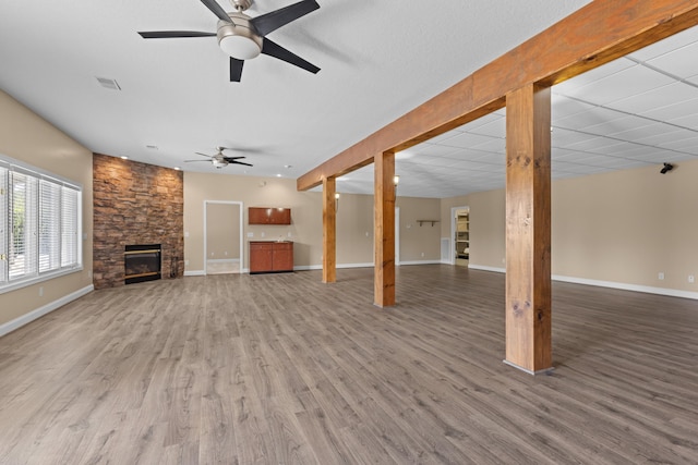 unfurnished living room featuring ceiling fan, a fireplace, and hardwood / wood-style floors