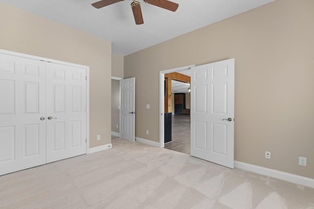 unfurnished bedroom featuring light carpet, a closet, and ceiling fan