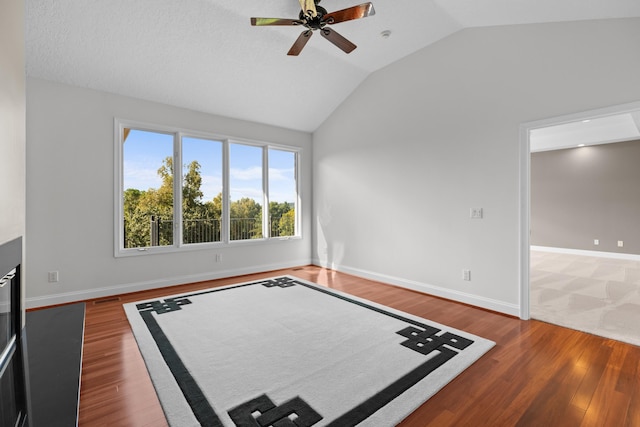 interior space with dark wood-type flooring, ceiling fan, and vaulted ceiling