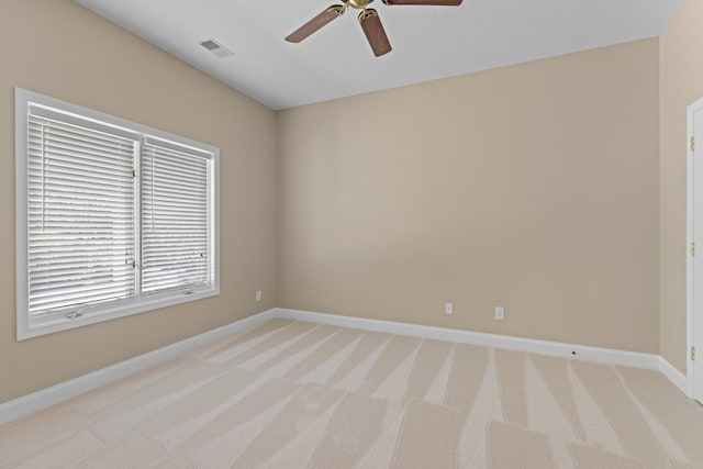 spare room featuring light colored carpet and ceiling fan