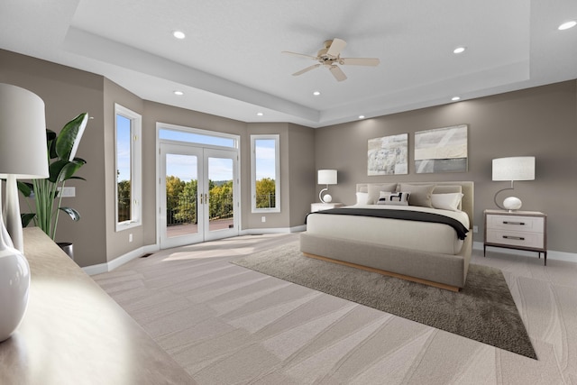 carpeted bedroom with french doors, ceiling fan, a tray ceiling, and access to exterior