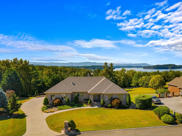 view of front of house featuring a water and mountain view and a front yard