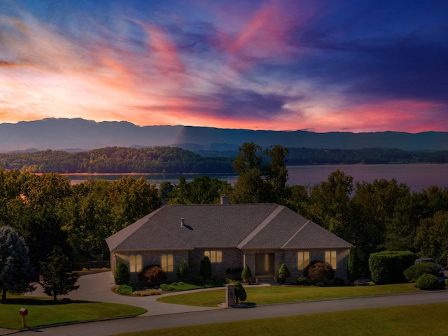 view of front facade featuring a yard and a water and mountain view