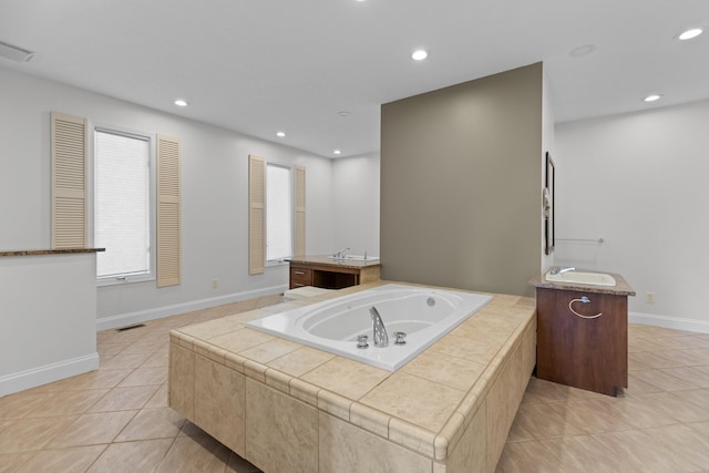 bathroom with vanity, a relaxing tiled tub, and tile patterned floors