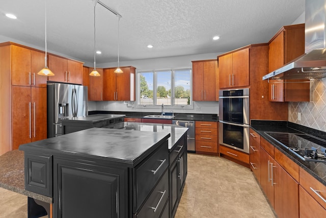 kitchen with sink, hanging light fixtures, stainless steel appliances, a center island, and wall chimney exhaust hood