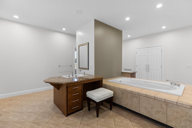 bathroom with vanity, tile patterned flooring, and tiled bath