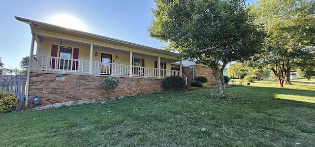 single story home featuring brick siding, covered porch, and a front yard