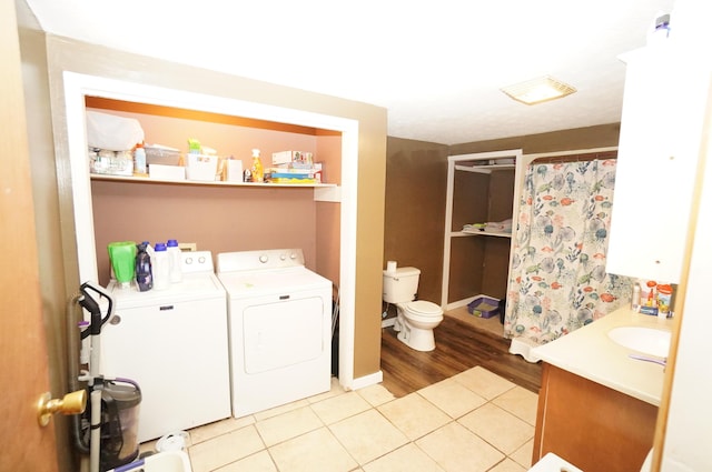 laundry room with washer and dryer, laundry area, light tile patterned floors, and a sink