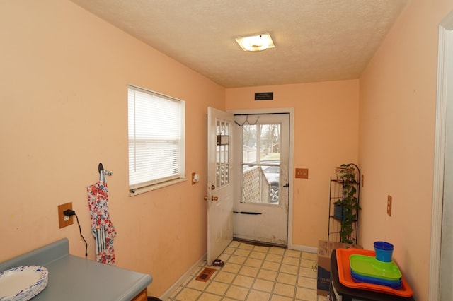 entryway with visible vents, baseboards, and a textured ceiling