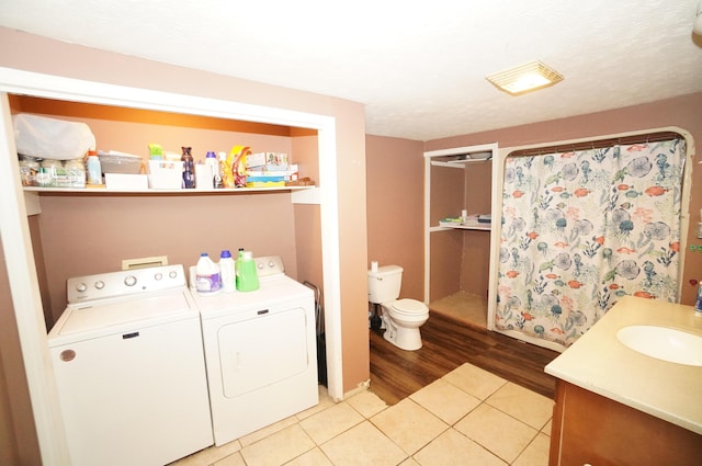 laundry room with a sink, light wood-style floors, washing machine and dryer, and laundry area