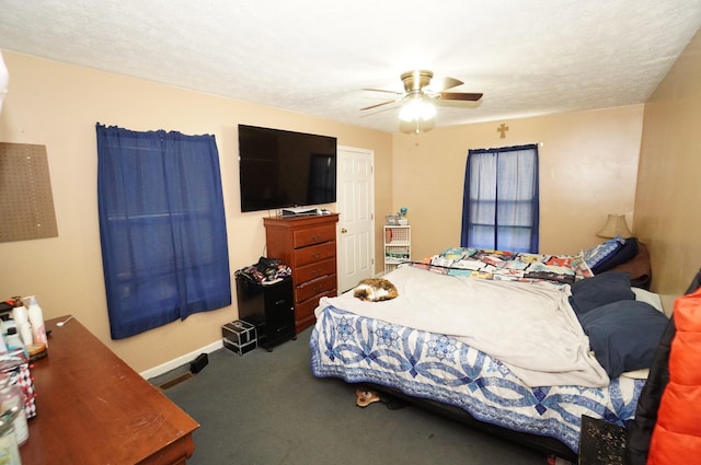 bedroom with a ceiling fan, baseboards, carpet floors, and a textured ceiling