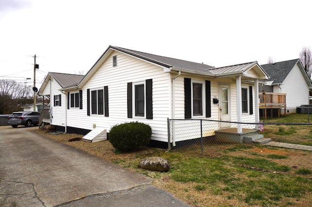 view of front of property featuring fence and metal roof