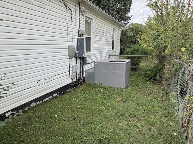 view of side of property featuring a yard and central AC unit