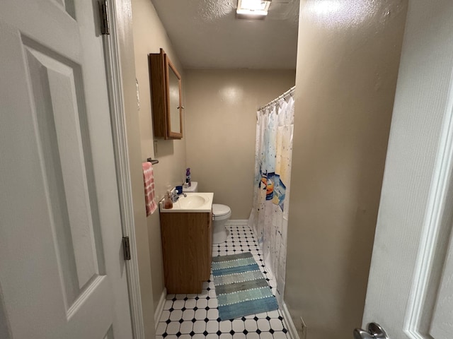 bathroom with vanity, a textured ceiling, and toilet