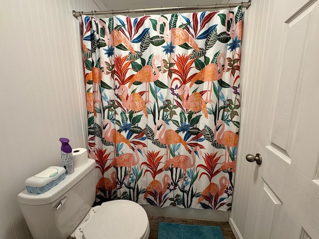 bathroom with curtained shower and toilet