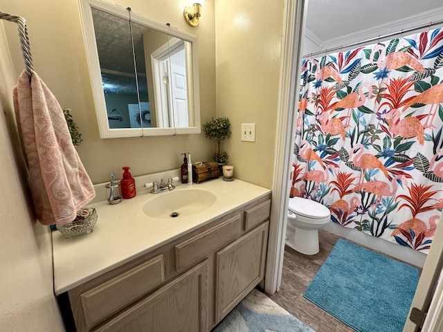 bathroom with walk in shower, crown molding, wood-type flooring, toilet, and vanity