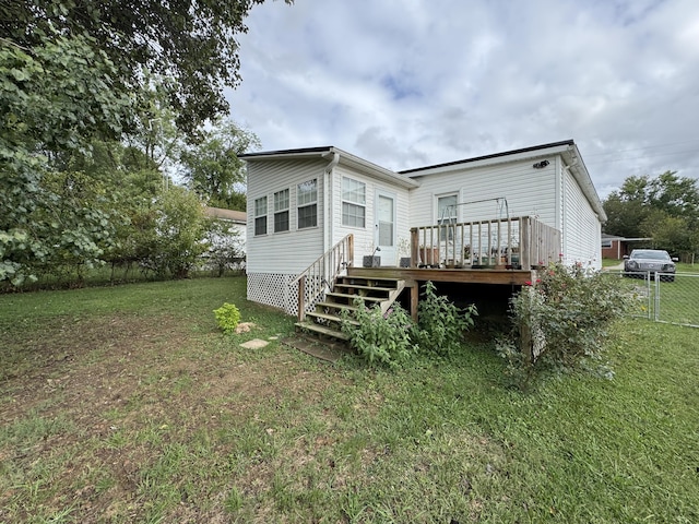 rear view of property with a lawn and a deck