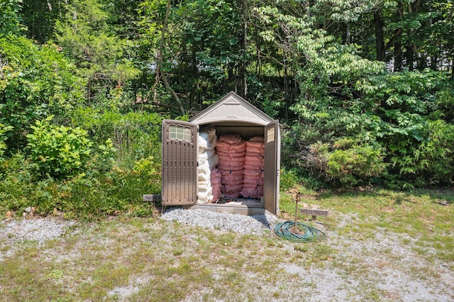 view of shed featuring a view of trees