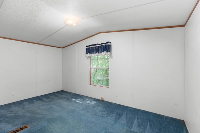 carpeted spare room with visible vents, ornamental molding, and vaulted ceiling